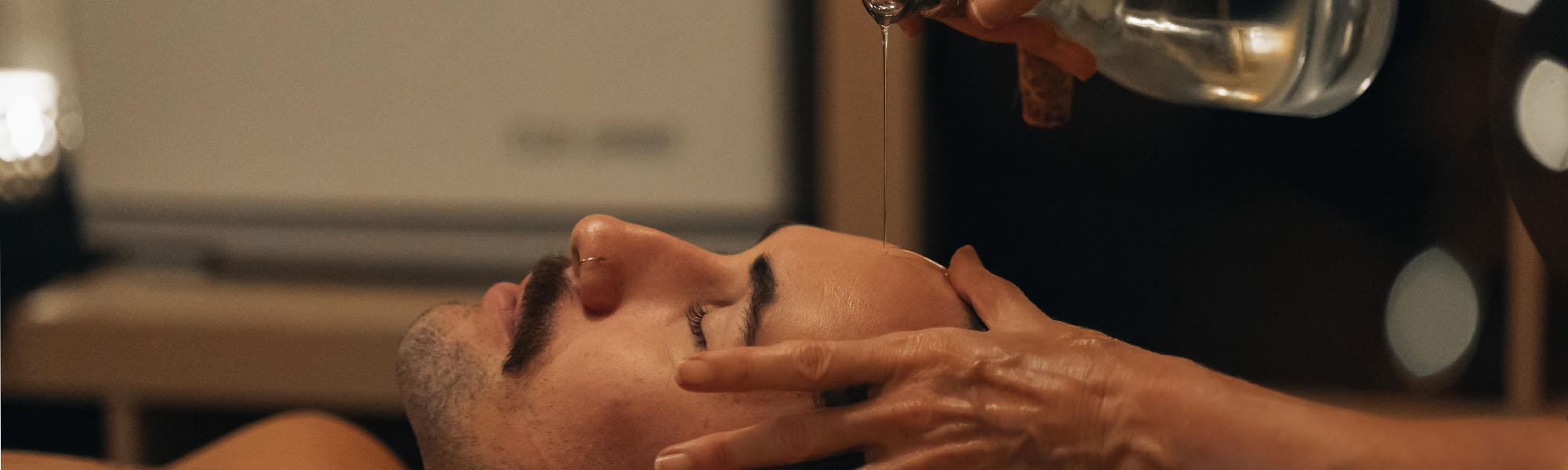 oil being poured over male head